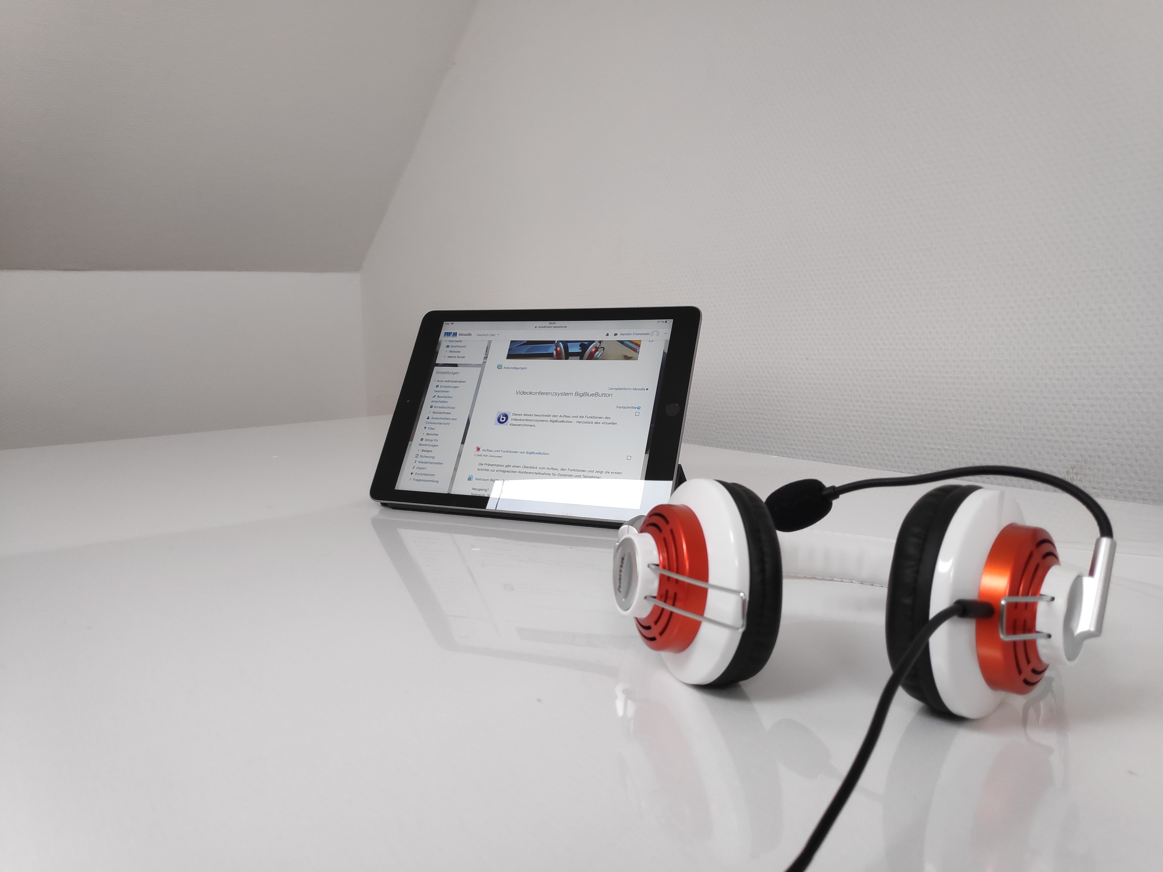 Tablet mit Headset auf weißem Tisch